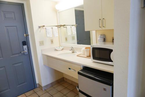 a kitchen with a sink and a microwave at Oceanview Lodge - Saint Augustine in St. Augustine