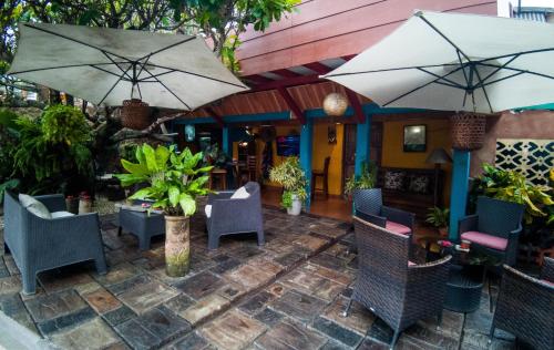an outdoor patio with chairs and umbrellas at Hotel Mar y Mar in Puntarenas
