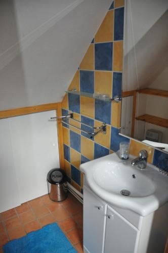 a bathroom with a sink and a tile wall at Gîte la Chamoussière in Saint-Mury-Monteymond