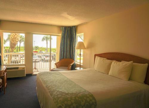 a hotel room with a bed and a balcony at Oceanview Lodge - Saint Augustine in Saint Augustine