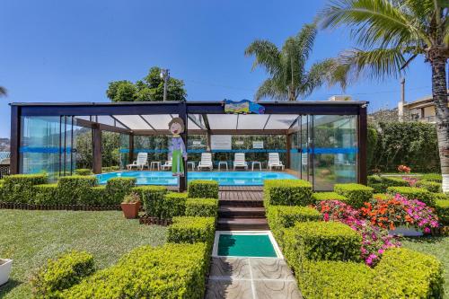 a house with a swimming pool in a garden at Hotel Sete Ilhas in Florianópolis