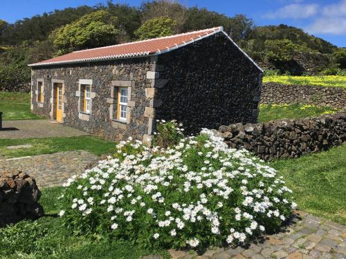 a stone building with white flowers in front of it at Pico da Vigia in Santa Bárbara