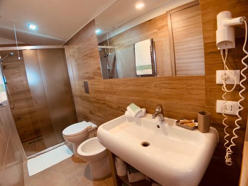 a bathroom with a sink and a toilet and a shower at Hotel Smeraldo in Qualiano