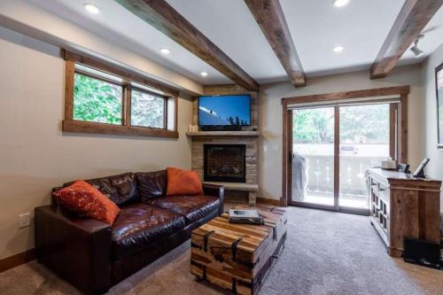a living room with a leather couch and a fireplace at Villa Cortina 130 in Vail Village in Vail
