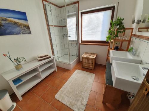 a bathroom with two sinks and a shower at Ferienwohnung Urlaub im Kraichgau in Sinsheim