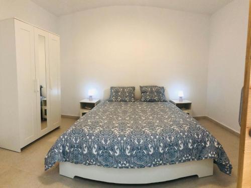 Un dormitorio con una cama grande con dos lámparas sobre dos mesas. en Suite ladybird, en Breña Baja