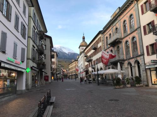 a city street with buildings and a mountain in the background at Apartment Sion Center in Sion