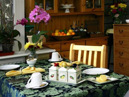 a table with plates and fruit on it with a table cloth at Linden Lodge Guest House in Weston-super-Mare