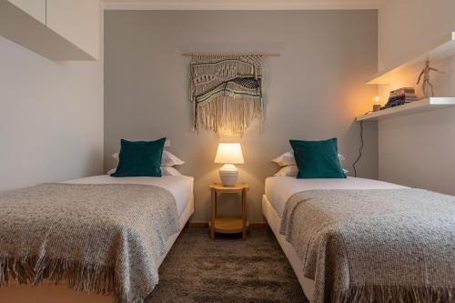 2 camas en una habitación con almohadas verdes en River View Apartment by Lisbon Heart, en Lisboa