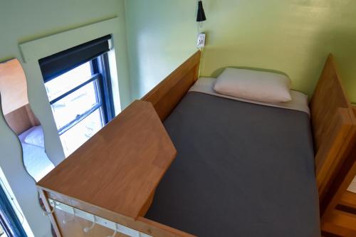 um pequeno quarto com uma cama e uma janela em Ocean Island Inn | Backpackers | Suites em Victoria