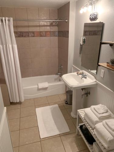a bathroom with a sink and a tub and a toilet at Artisan Downtown in DeLand