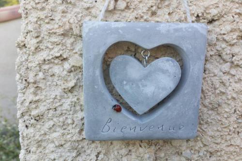 un cœur en pierre suspendu à un arbre avec une mouche dans l'établissement VILLA LA LURETTE, appartement et studio, à Saint-Étienne-les-Orgues