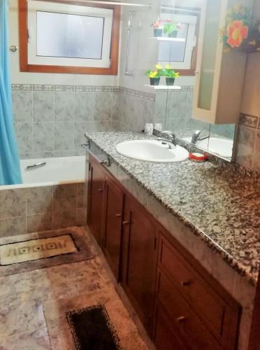 a bathroom with a sink and a tub and a mirror at Casa da Fátima, in Vila Chã