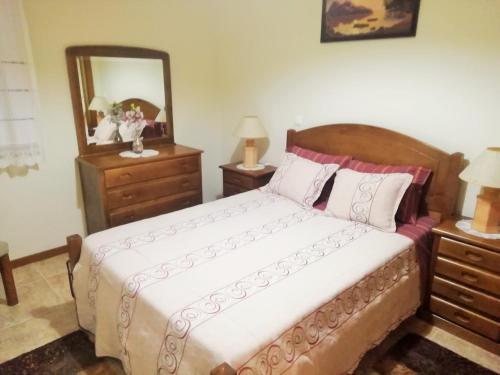 a bedroom with a bed and two dressers and a mirror at Casa da Fátima, in Vila Chã