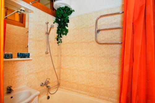 a bathroom with an orange shower curtain and a sink at Central Area Apartments in Kyiv