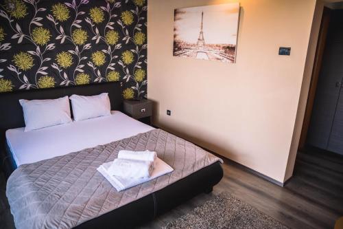 a bedroom with a bed and a picture of the eiffel tower at Guest House Vila Salute in Niš