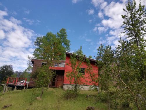 una casa roja situada en la cima de una colina en Cabaña en Caburgua, Pucon, en Pucón
