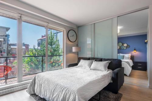 a bedroom with a bed and a large window at Clean 3rd Floor Executive 1 BR Apt in Old Town China Town in Victoria