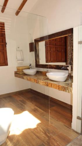 uma casa de banho com 2 lavatórios e um espelho em CasaNeral_Barichara em Barichara