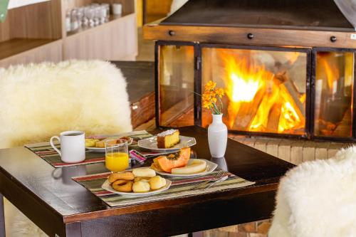 邦雅尔丁-达塞拉峡谷农场之路酒店的餐桌,餐盘和壁炉