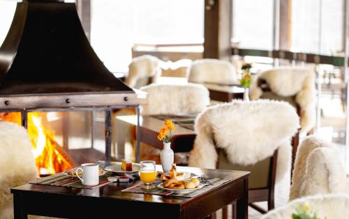 邦雅尔丁-达塞拉峡谷农场之路酒店的壁炉旁的桌子上放着一盘食物。