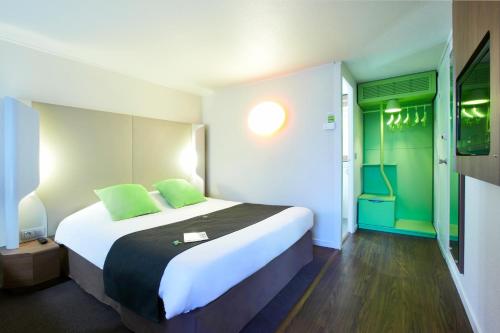 a bedroom with a large bed with green accents at Campanile Montbéliard - Sochaux in Sochaux