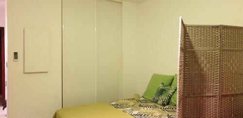 a bedroom with a bed and a headboard and a chair at T1 tout confort in Saint-Denis