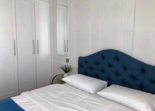 um quarto com uma cama com uma cabeceira azul e armários brancos em Silverscape Seaview B25-13 em Malaca