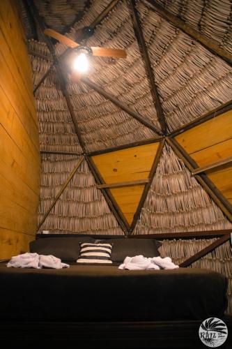 a room with a bed in a thatched ceiling at Raiz Kite Cabana in Jericoacoara