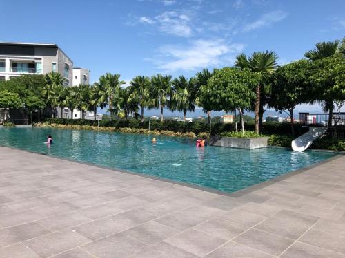een zwembad met mensen in het water bij The Loft Imago in Kota Kinabalu