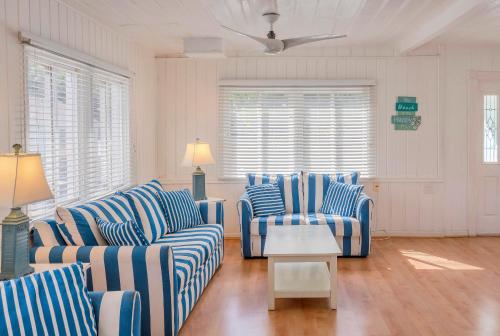 a living room with blue and white striped couches and a table at Twins Inn & Apartments in St Pete Beach
