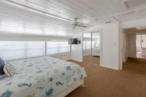 a bedroom with a bed and a ceiling fan at Twins Inn & Apartments in St Pete Beach