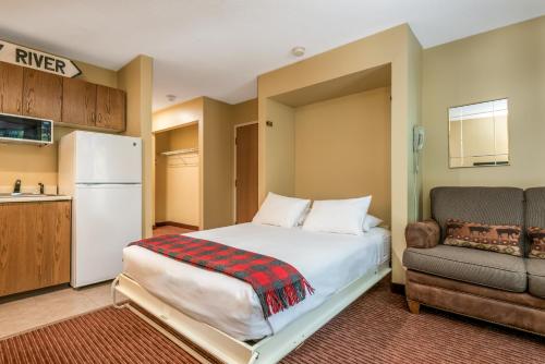 a bedroom with a bed and a couch and a refrigerator at Grand Summit Hotel in Newry