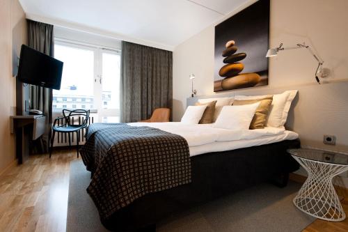 a hotel room with a large bed and a television at Hotel Birger Jarl in Stockholm