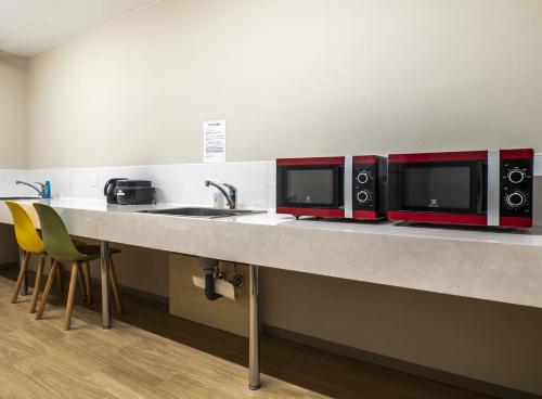 a kitchen counter with two microwaves and a sink at My Ecolodge in Kutchan