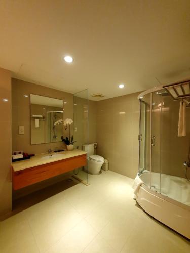 a bathroom with a tub and a sink and a shower at Saigon Hotel in Ho Chi Minh City