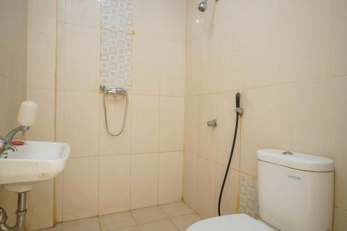 明古魯的住宿－RedDoorz Syariah At Hotel Putri Gading Bengkulu，带淋浴、卫生间和盥洗盆的浴室