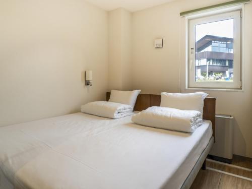 2 camas en una habitación con ventana en My Ecolodge, en Niseko