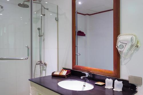 a bathroom with a sink and a shower and a mirror at PP Erawan Palms Resort- SHA Extra Plus in Phi Phi Islands