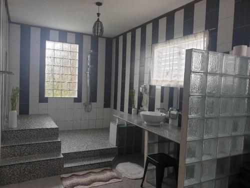 ein Bad mit einem Waschbecken und blauen und weißen Fliesen in der Unterkunft TipTop Hotel, Resto and Delishop in Panglao