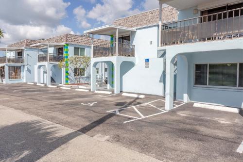 a row of white buildings in a parking lot at Twins Inn & Apartments in St Pete Beach
