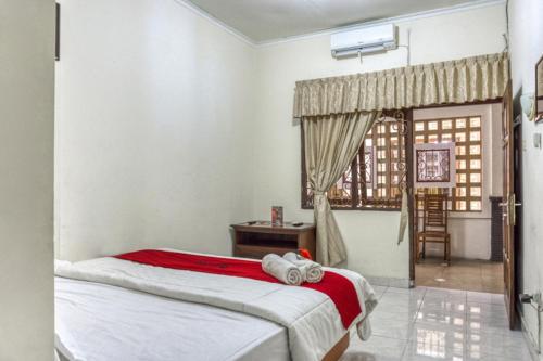 een slaapkamer met een bed en een raam bij RedDoorz Syariah @ Raya Tajem Maguwo in Kalasan