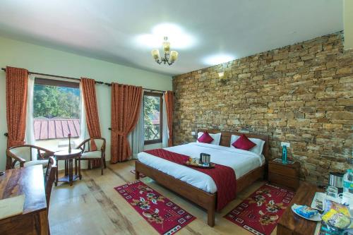 a bedroom with a bed and a brick wall at StayVista at Garbyang Homestay in Nainital