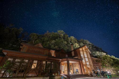 a building with people standing outside at night at Hotel Kifu Club Shiretoko in Shari