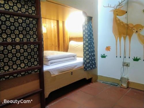 a bedroom with a bed with a deer on the wall at Matsu 1st Hostel in Nangan