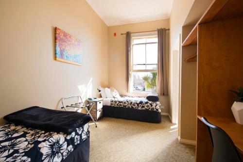 a room with two beds and a window at The Prince Albert Backpackers & Bar in Nelson