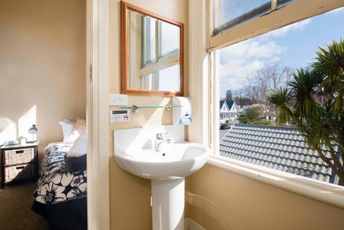 uma casa de banho com um lavatório e uma janela em The Prince Albert Backpackers & Bar em Nelson