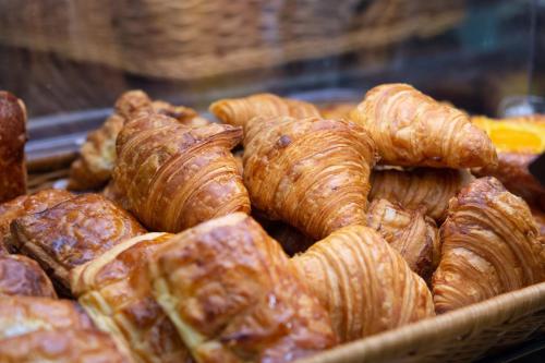 a pile of croissants and other pastries in a basket at SureStay Hotel by Best Western Vientiane in Vientiane