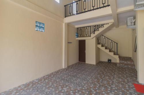 an empty room with stairs and tile floors at RedDoorz Syariah near Politeknik Negeri Madiun in Madiun