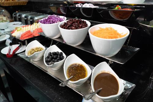 a buffet with bowls of different types of food at SureStay Hotel by Best Western Vientiane in Vientiane